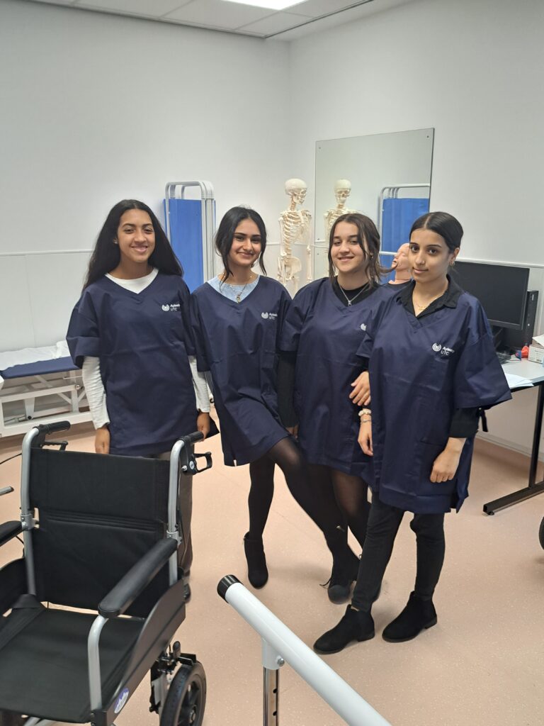 4 Aylesbury UTC Sixth Form students studying Health and wearing Navy Scrubs and in Physio and triage area of the Health Suite